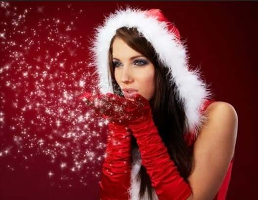 Woman in Santa outfit blowing glitter