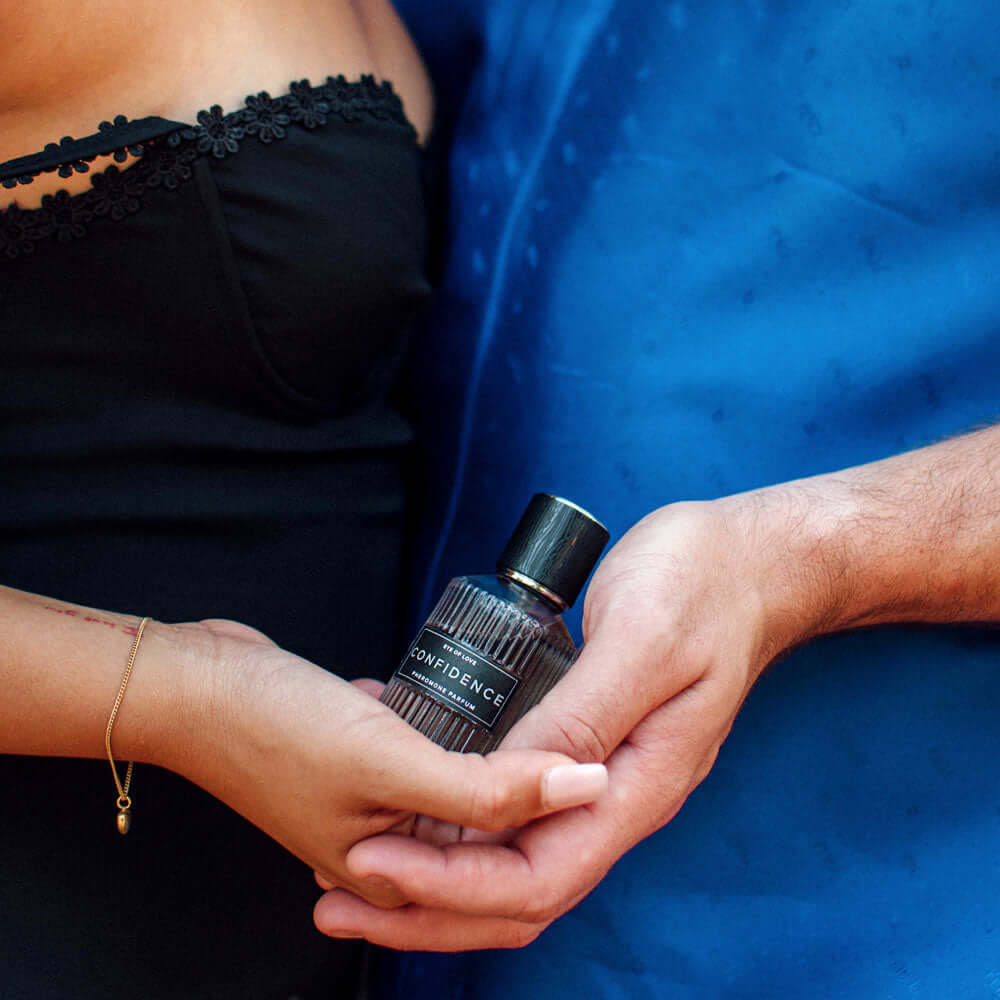 Couple holding Confidence perfume bottle