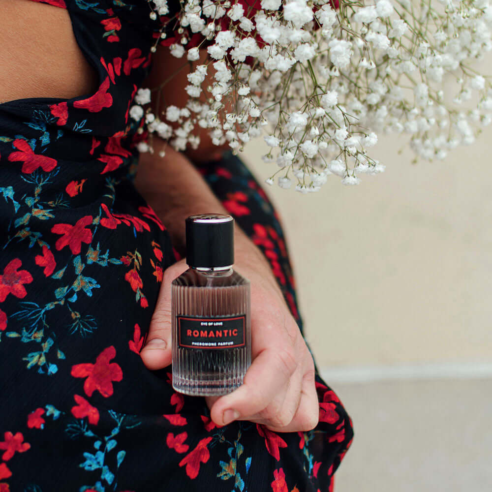 Romantic perfume held with flowers